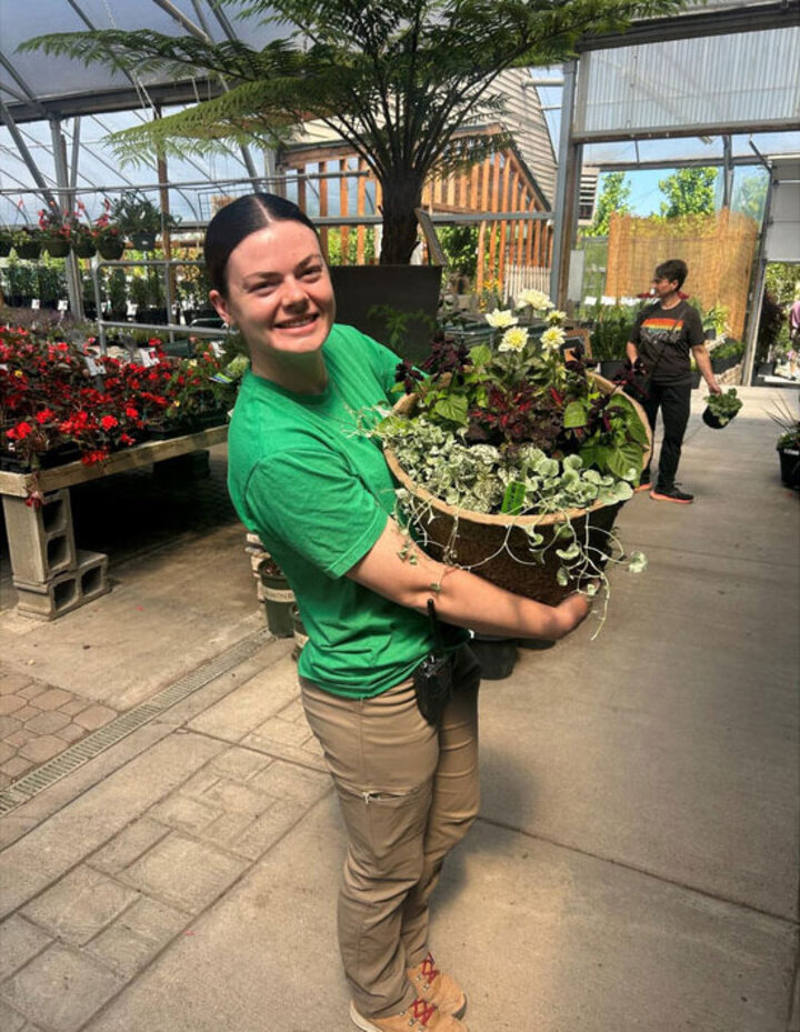 Emily holding a plant.